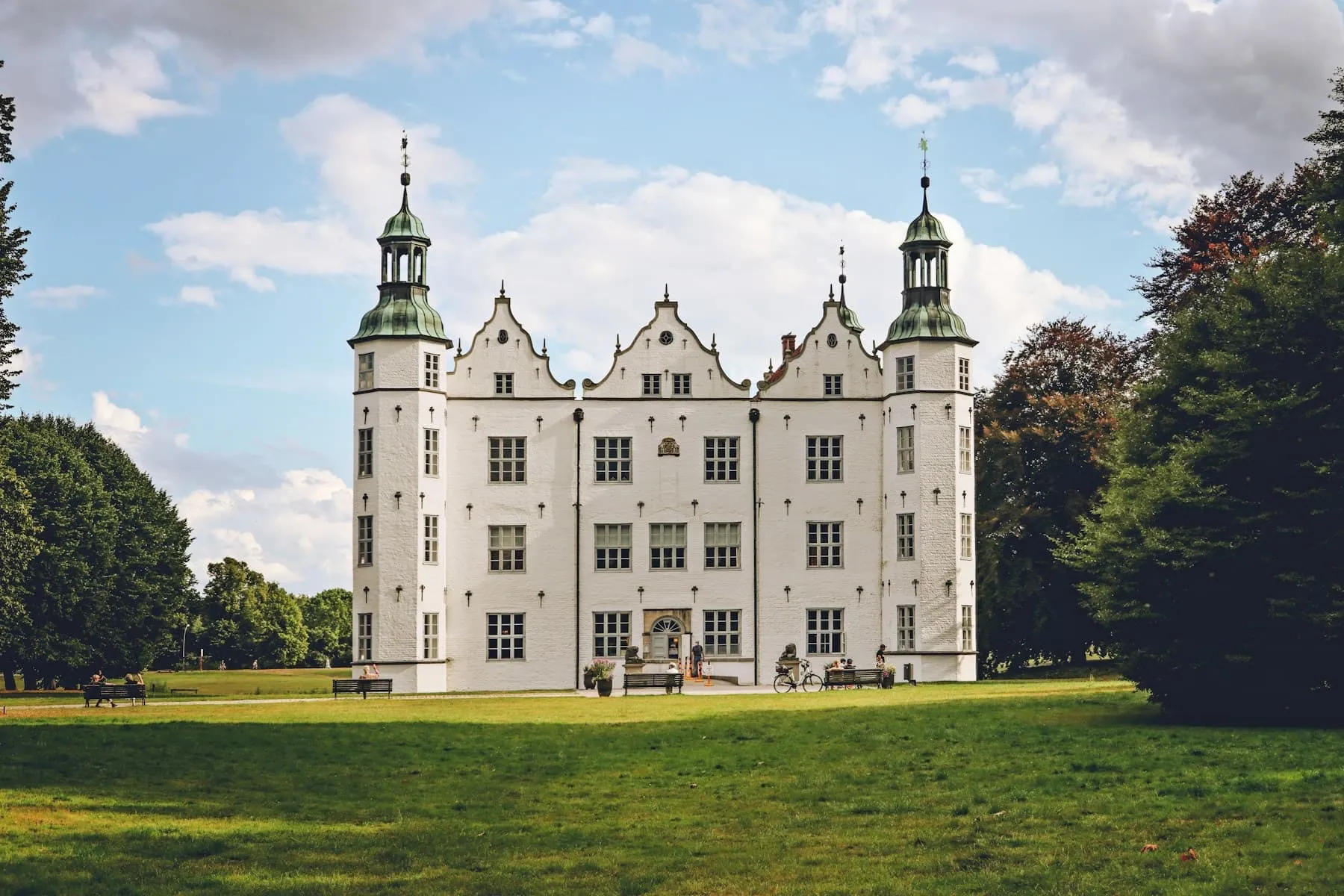 Das weiße Schloss Ahrensburg auf einer grünen Wiese