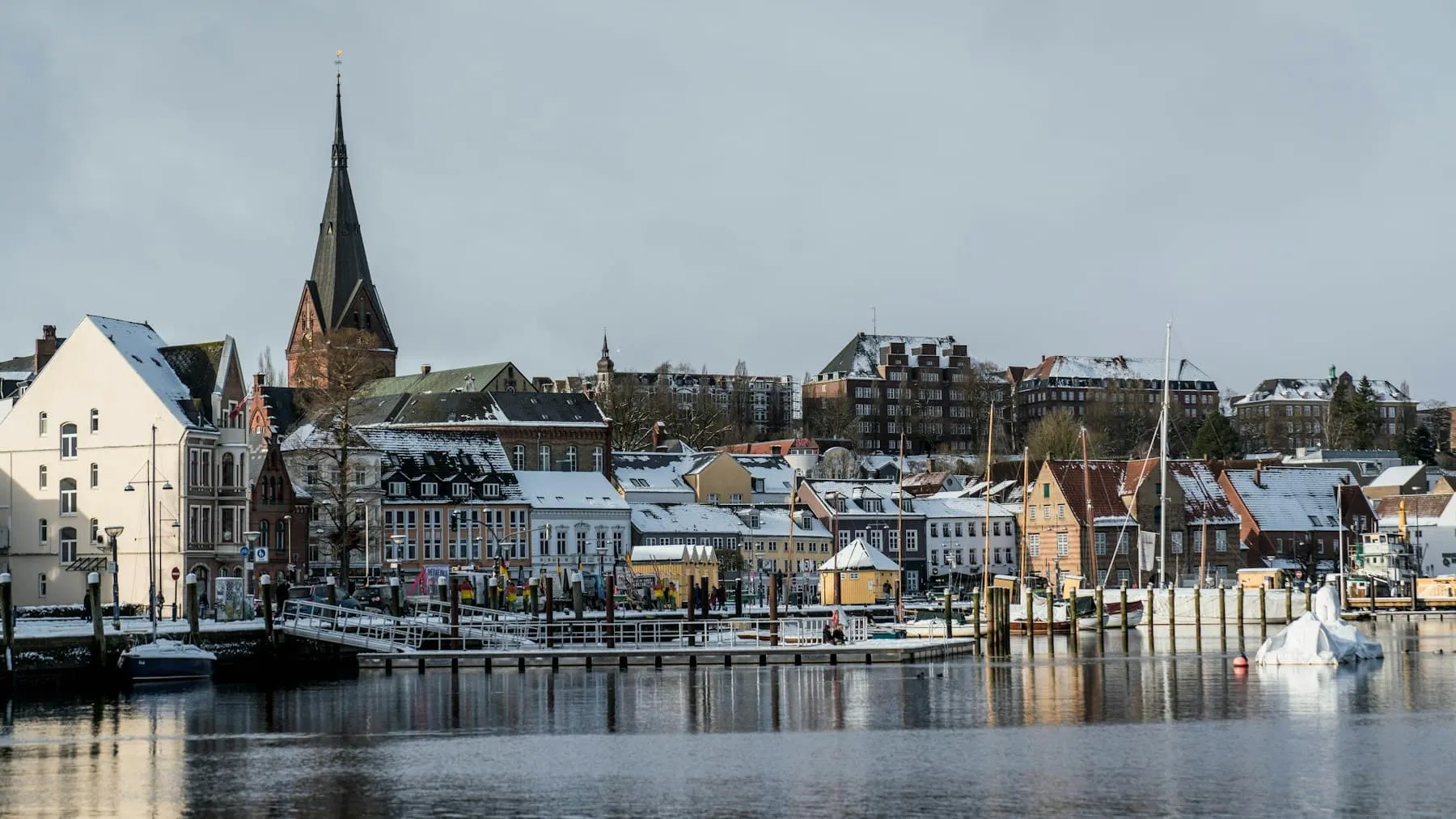 Flensburger Hafen mit Booten und verschneiten Häusern